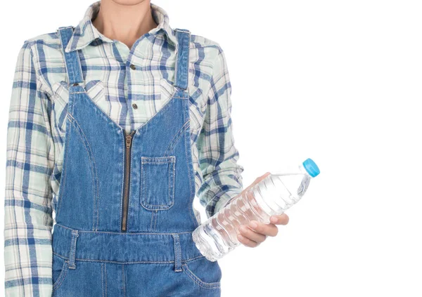 Młoda kobieta w koszuli w kratę i dżinsy śliniaczek trzymając wodę butelki jest — Zdjęcie stockowe