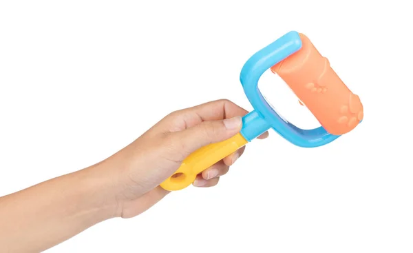 Hand holding plastic tool roller brush of beach toy isolated on — Stockfoto