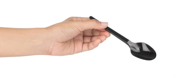 Mână care ține lingura de plastic negru izolată pe fundal alb . — Fotografie, imagine de stoc