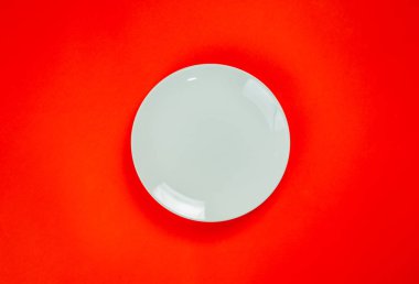 A white plate on red background