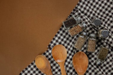 Collections of spices bottle with tablecloth on brown background