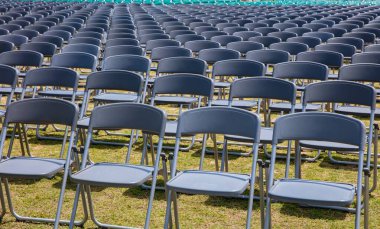 Rows of grey chairs on lawn ceremony in summer time