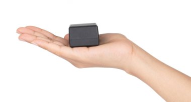 El ele tutuşan küçük siyah kutu beyaz arka planda izole edilmiş.