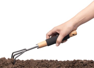 El kazma toprağı beyaz arka planda izole edilmiş tırmıkla