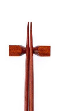 pair of wood chopsticks with wood holder isolated on a white bac