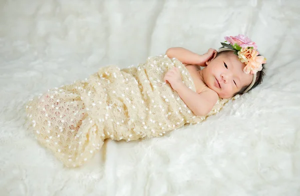 Close up Niedliche Neugeborene tragen Blume Stirnband auf weißem Wollkarpfen — Stockfoto
