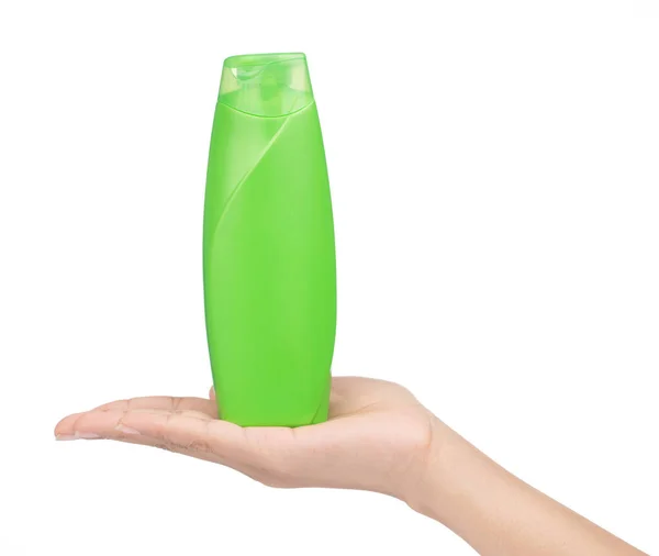 Hand holding green plastic bottle of shampoo isolated on white b — Stock Photo, Image