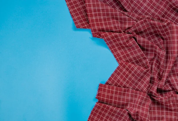 Red checkered tablecloth on blue background — 图库照片
