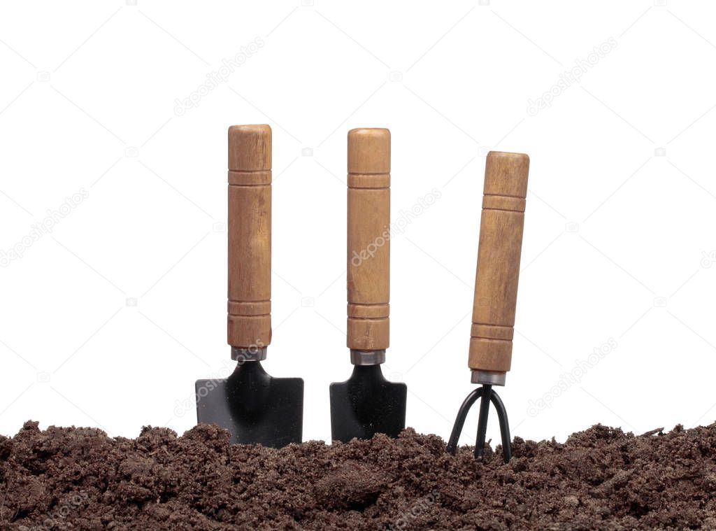 set garden tools in soil isolated on white background