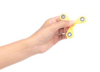 fingers playing a yellow fidget spinner isolated on a white back
