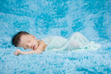 Yeni doğmuş güzel bir bebek, sargı bezi içinde. Rahatlıyor.