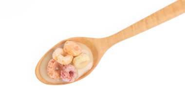close up of colorful cereal and milk with spoon isolated on white background