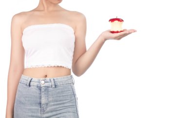 young woman wearing white strapless dress and jeans holding red 