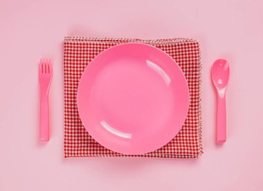 Pink color plastic plate with plastic spoon, fork and cloth napk