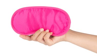 El ele tutuşan pembe uyku maskesi beyaz bir arka planda izole edilmiş.