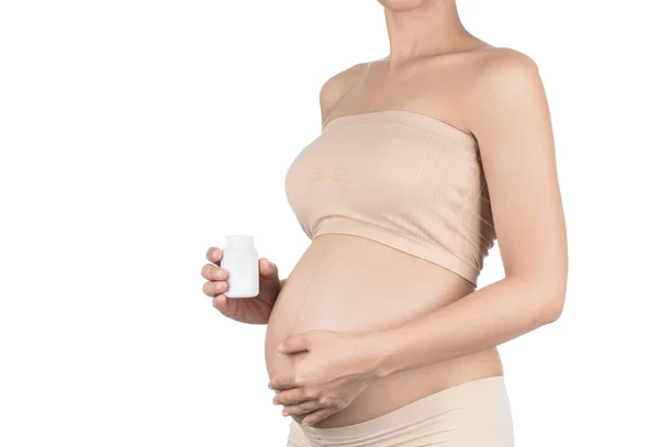 Vientre de la mujer embarazada y pastillas en la mano aisladas en blanco — Foto de Stock