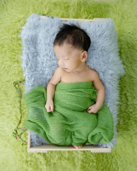 Retrato de bebê bonito deitado dormindo em caixa de madeira . — Fotografia de Stock