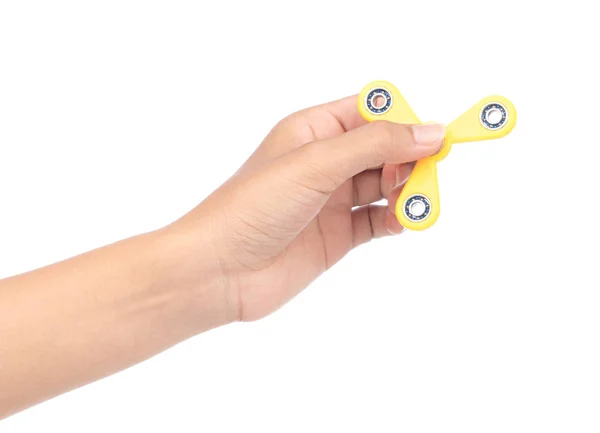 Fingers playing a yellow fidget spinner isolated on a white back — ストック写真