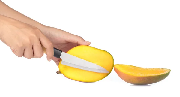 Τα χέρια κόβουν ένα ώριμο μάνγκο με ένα μαχαίρι απομονωμένο σε άσπρο βαρέλι. — Φωτογραφία Αρχείου
