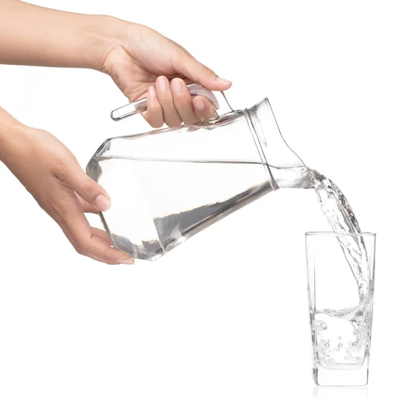 Hand pouring water from glass jug to glass isolated on a white b — 图库照片