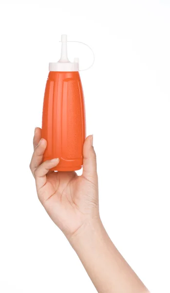 Mão segurando garrafa de plástico de molho de pimenta isolado no bac branco — Fotografia de Stock