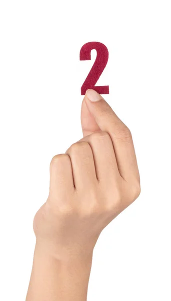 Mão segurando Número 2 feito de feltro isolado no fundo branco — Fotografia de Stock