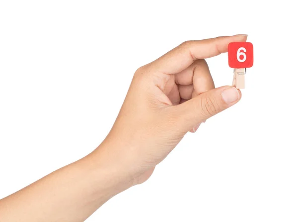 Hand hält Clip Holzstift mit Zahlen 6 isoliert auf einem weißen — Stockfoto