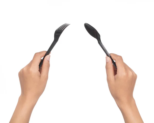 Mano sosteniendo Cuchara y tenedor de plástico negro aislado en la espalda blanca —  Fotos de Stock