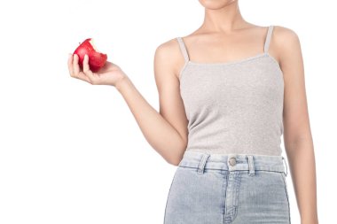 woman in grey tank top and jeans eating one red apple isolated o