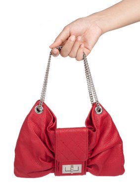 El ele tutuşan kırmızı kadın çantası beyaz arka planda izole edilmiş..
