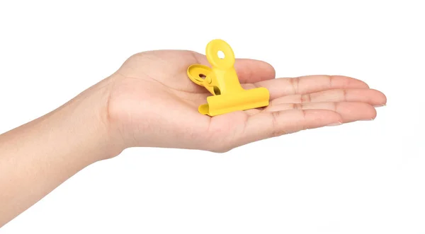 Mão segurando clipe de papel de aço inoxidável amarelo isolado no branco — Fotografia de Stock