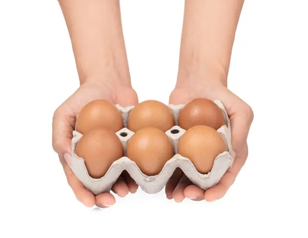Рука держа яйца в бумажном лотке изолированы на белом фоне. — стоковое фото