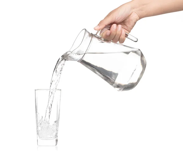 Hand pouring water from glass jug to glass isolated on a white b — 图库照片