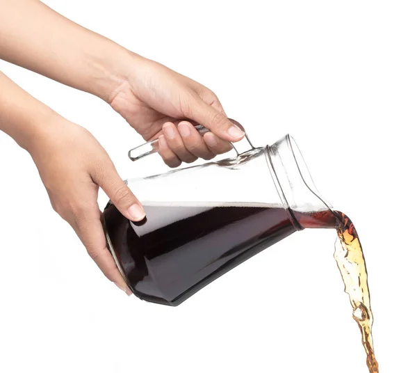 Hand gießt Cola in einen Krug, isoliert auf weißem Hintergrund — Stockfoto