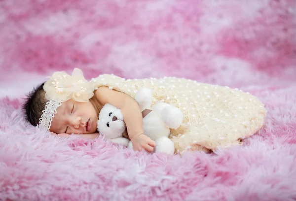 Küçük bebek uzanmış oyuncak ayıya sarılıyor. — Stok fotoğraf