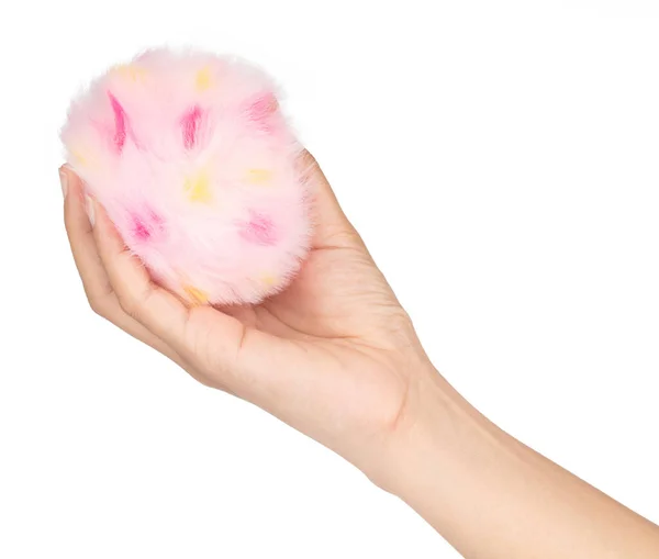 Χέρι κρατώντας ροζ γούνα μπάλα απομονώνονται σε λευκό φόντο — Φωτογραφία Αρχείου