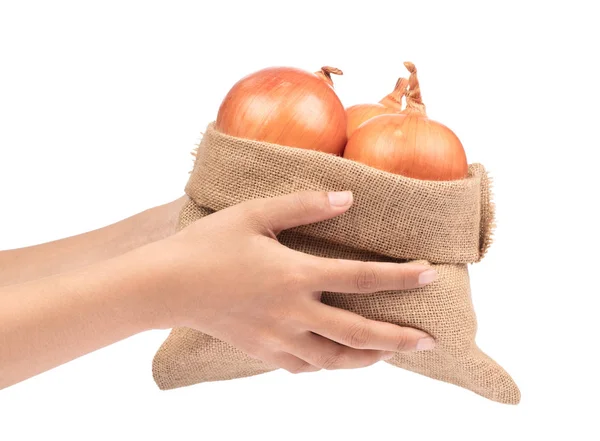 Χέρι κρατώντας φρέσκο κρεμμύδι σε σάκο λινάτσα που απομονώνονται σε λευκό ba — Φωτογραφία Αρχείου