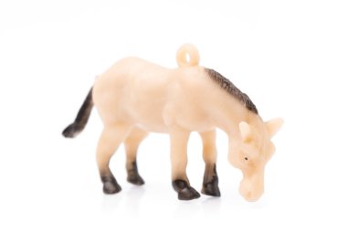 Beyaz arka planda plastikten yapılmış oyuncak at.