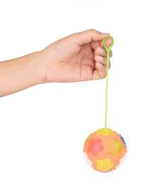 El ele tutuşan lastik top, dikenleri beyaz bir baloda izole edilmiş.