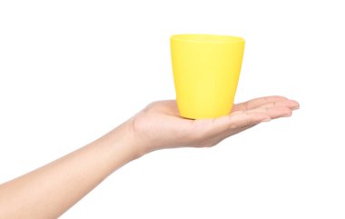 hand holding a yellow plastic glass isolated on a white backgrou