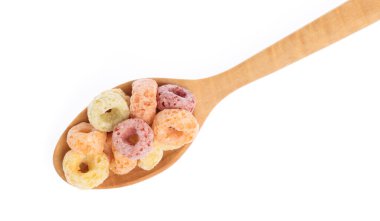 close up of colorful cereal and milk with spoon isolated on white background