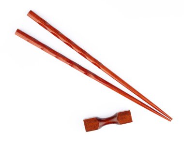 pair of wood chopsticks with wood holder isolated on a white bac