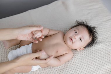 Yatakta yatan meraklı küçük bir bebeğin portresi. 