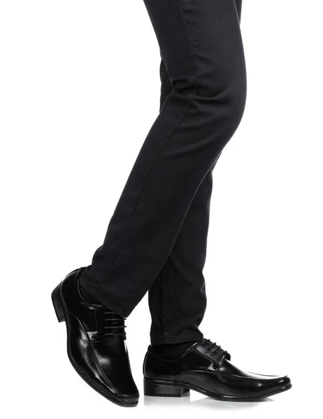 Pies de hombre en pantalones negros y zapatos negros aislados en blanco b — Foto de Stock