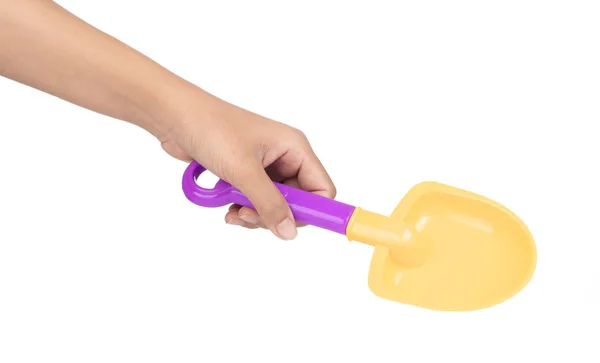 Hand holding plastic tool shovel of beach toy isolated on white — Stockfoto