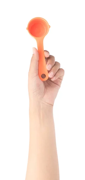 Рука тримає помаранчеву пластикову совок ізольовано на білому тлі — стокове фото