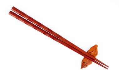 pair of wood chopsticks with wood holder isolated on a white bac