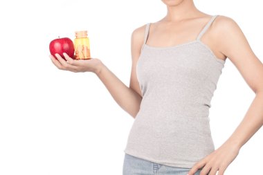 woman in grey tank top and jeans holding red apple with bottle o