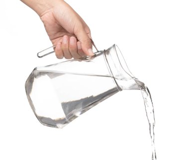 Hand pouring water from glass jug to glass isolated on a white b