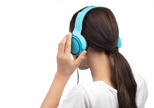 Junge Frau hört Musik in einem blauen Kopfhörer isoliert auf Weiß — Stockfoto